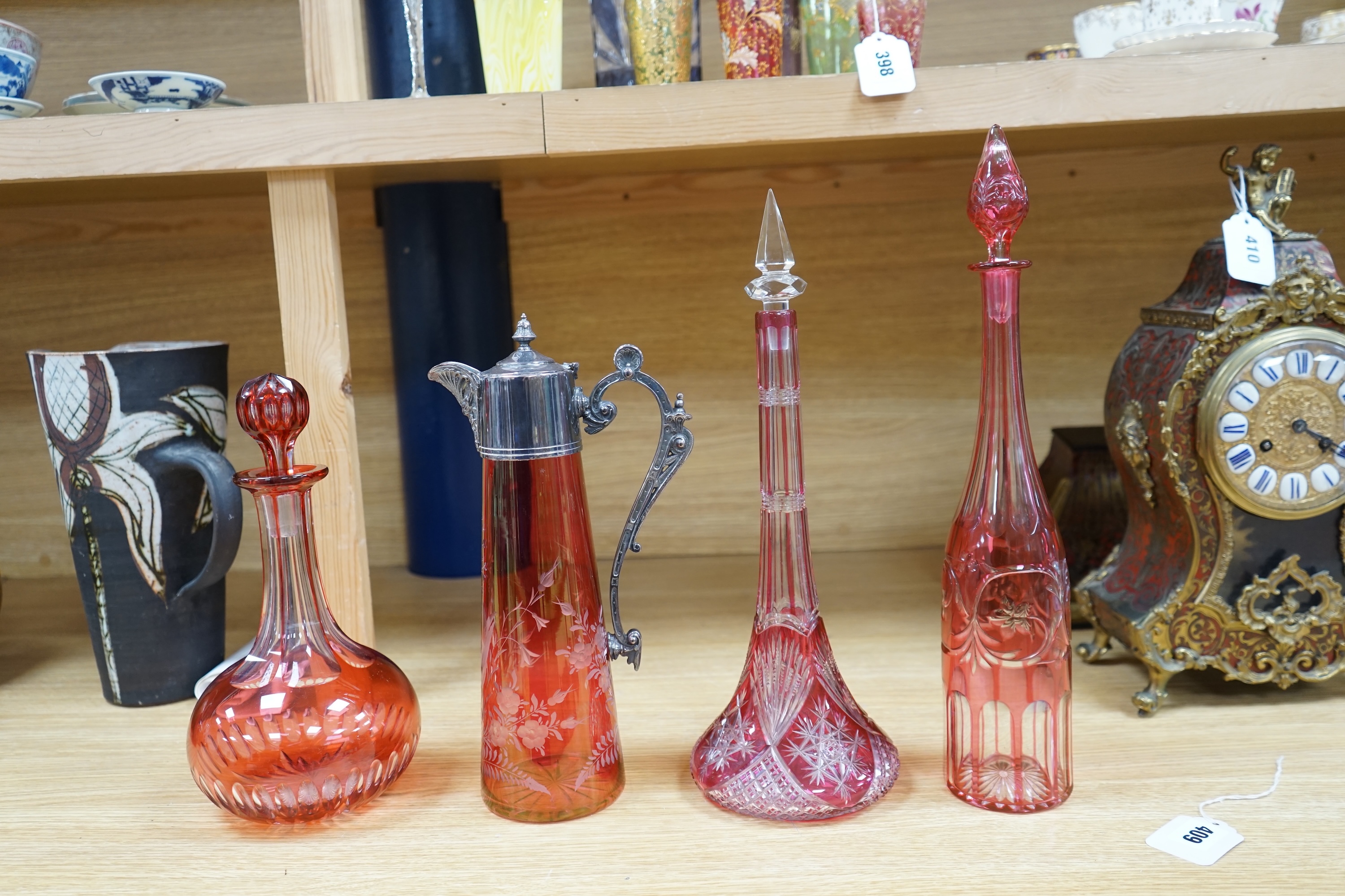 A collection of cranberry glassware comprising three decanters with stoppers and a silver plate mounted ewer, largest 41cm high. Condition - fair to good